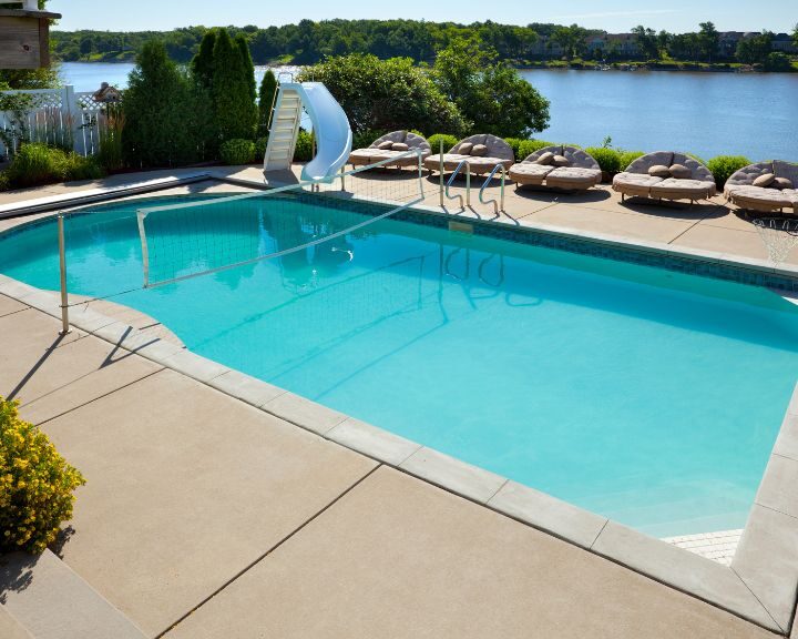 a large pool deck next to a large body of water.
