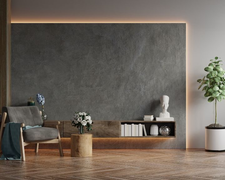 A city living room with a chair and a bookshelf against concrete walls.